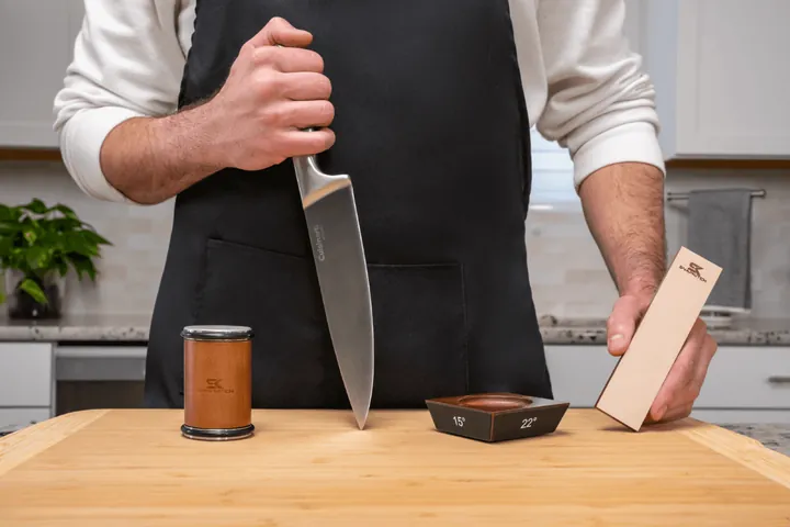 Chef sharpening a kitchen knife on a whetstone, kitchen product photography