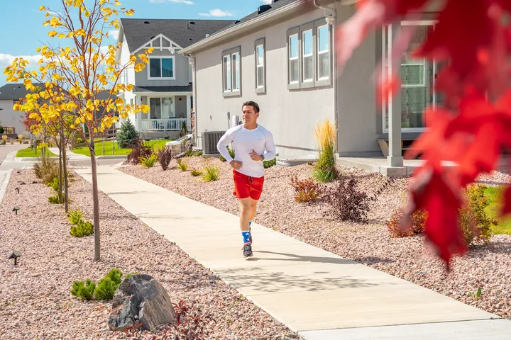 Runner on a neighborhood sidewalk in fall, apparel lifestyle photography